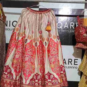 Our skilled technician carefully treats a delicate silk dress using precision stain-removal methods in Gurgaon. Close-up of a professional dry cleaner treating a delicate silk dress with advanced stain removal techniques in Gurgaon