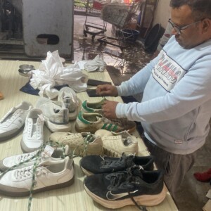 From sneakers to leather — expert shoe care for a fresh and polished look. Professional shoe cleaning in progress using a brush and cleaning solution